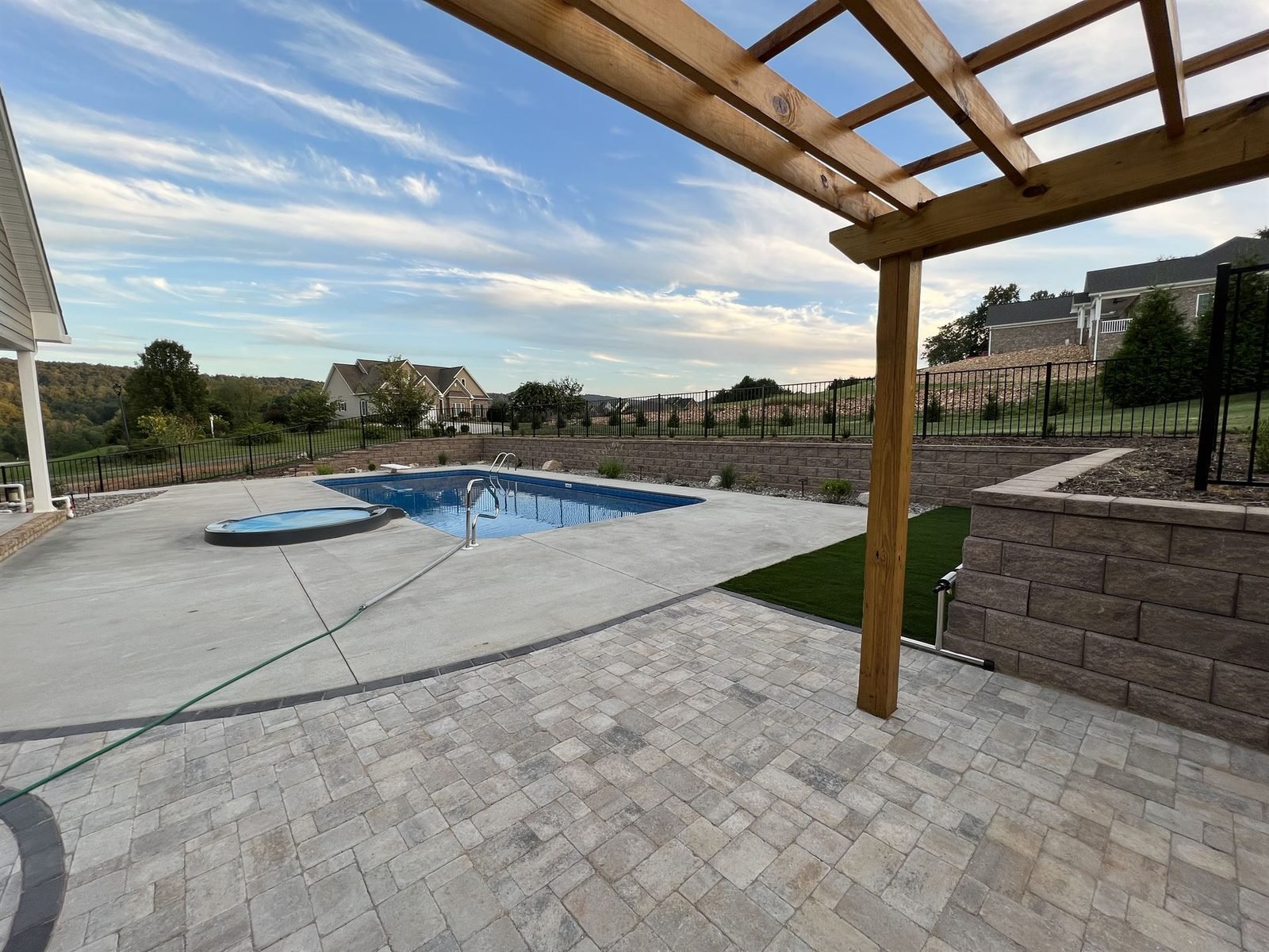 Pergola, pool, and paver patio at dusk Western NC
